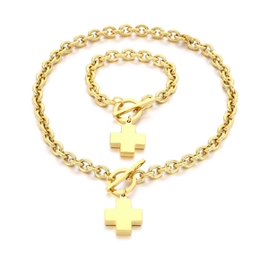 Golden stainless steel OT buckle jewelry set with cross and round charms on white background