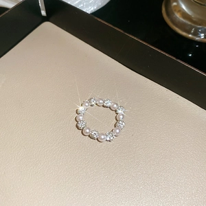 Detailed view of beaded ring with white pearls and sparkling rhinestone metal beads
