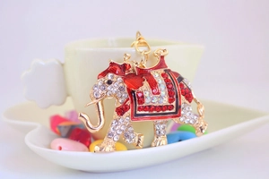 Close-up of golden elephant keychain with sparkling rhinestones and red enamel details