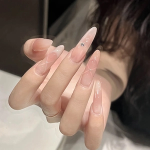 Detail of long almond press-on nails with white French tips and rhinestone accents