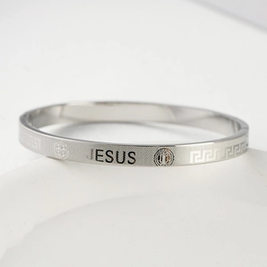 Detail of silver stainless steel bracelet featuring JESUS engraving and religious icons