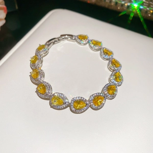Macro view of teardrop yellow gemstone bracelet with white zircon pave in silver finish