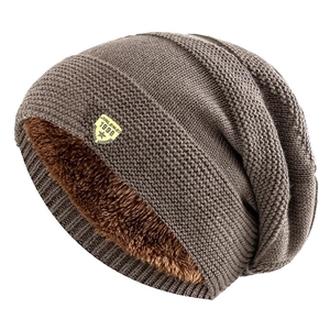 Detailed view of dark brown knitted beanie with warm fleece lining and logo patch