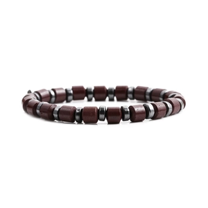 Bracciale magnetico con perline a cilindro rosso scuro e dischi grigio metallo su sfondo bianco