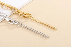 Close-up of golden and silver double-layer bracelet extension chain and lobster clasp