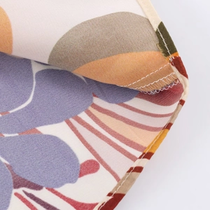 Détail du tissu satiné lisse avec imprimé floral coloré et couture de précision