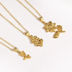 Detailed view of three 18K gold-plated floral necklaces with rose and daisy pendants