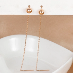Detailed view of long rose gold bead chain tassel earrings hanging on display card