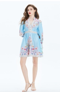 Détail de la robe fleurie bleu clair à manches lampions et taille marquée col en V