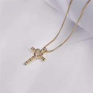 Macro shot of gold cross and heart pendant with colorful micro-pave cubic zirconia
