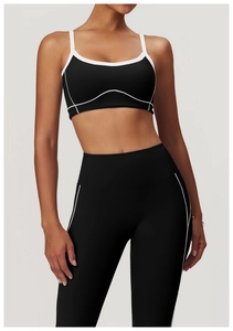 Détail d'un ensemble de brassière et legging de sport noirs avec liserés blancs