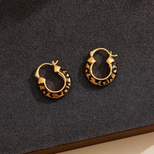 14k gold plated hoop earrings with vintage leopard print enamel on a textured background