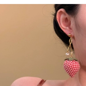 Detail of strawberry drop earring with red gingham fabric and elegant pearl accent