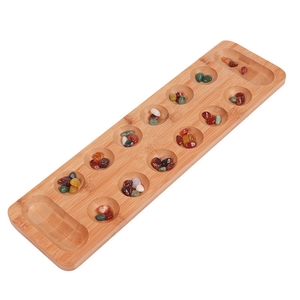 Detailed macro view of colorful glass stones inside a natural wooden Mancala board pit
