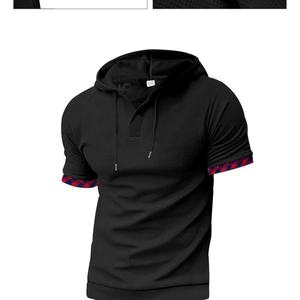 Detail of black waffle knit polo shirt featuring red and blue plaid cuffs and a drawstring hood