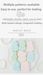 Detail of forest house biscuit molds set and baked cookies on a white plate