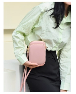 Detail of pink PU leather vertical mini crossbody bag with golden zipper and strap