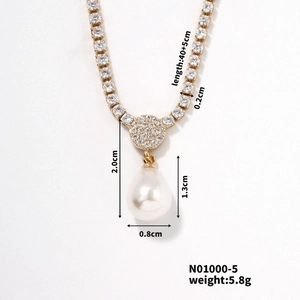 Macro shot of gold pendant with rhinestones and a water drop pearl showing precise dimensions
