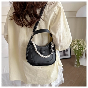 Detailed view of black matte leather heart embossed bag with decorative pearl chain strap