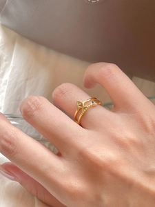 Detailed shot of a gold double-layer silver ring with a small fish design and a diamond