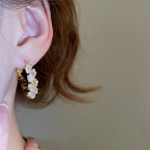 Detail of 18k gold plated hoop earring with tiger eye and marquise cubic zirconia stones