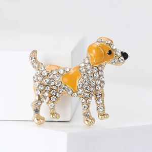 Detailed close-up of a golden dog brooch with yellow enamel and sparkling crystals
