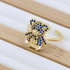 Detailed close-up of a golden teddy bear ring set with sparkling blue zircon stones
