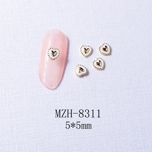 Detailed close-up of 5x5mm gold metal heart nail charms with white enamel finish
