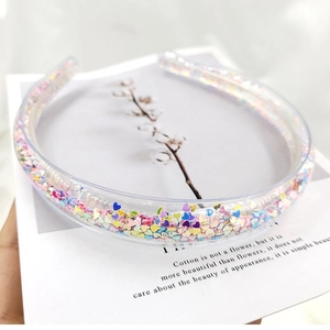 Close-up of transparent hairband filled with colorful heart sequins and non-slip teeth