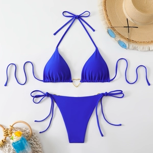 Royal blue triangle bikini set with gold heart ring details and beach vacation accessories