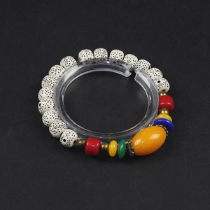 Detailed view of colorful ethnic beaded bracelet on a clear circular display stand
