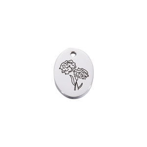 Detailed close-up of oval stainless steel necklace pendant with floral line engraving