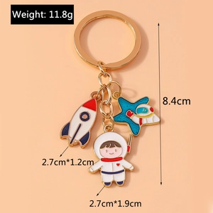 Detail of space-themed keychain with astronaut and rocket charms showing dimensions