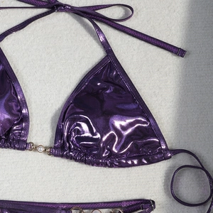 Macro shot of metallic purple bikini top featuring elegant pearl center decoration