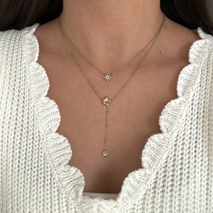 Detail of gold-plated stainless steel Y-shaped double necklace with star and flower pendants