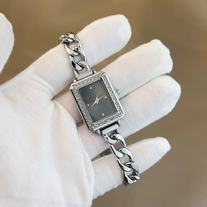 Close-up of elegant women's square quartz watch with diamond accents and silver chain band