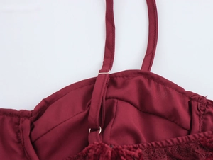 Detail of dark red sequin bodice with adjustable straps and delicate lace trim accents