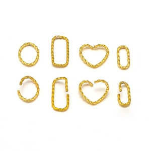 Detailed view of twisted gold-plated jump rings in heart, circle, and oval shapes