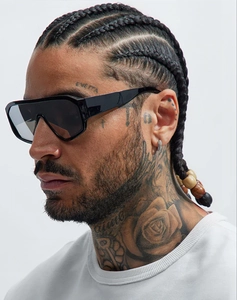 Side profile of large black shield sunglasses on model with silver hoop earring