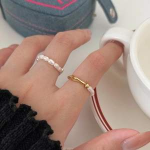 Close-up of elegant gold irregular rings with pearls worn for a sophisticated style