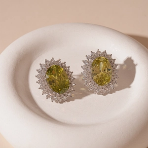 Detailed view of oval olive green gemstone earrings with sparkling zircon halo setting
