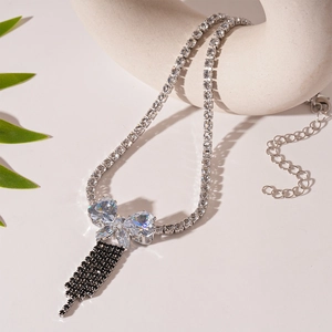 Detail of silver butterfly pendant with sparkling cubic zirconia and black tassel fringe