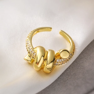 Macro shot of gold geometric ring with micro-set cubic zirconia on luxury silk