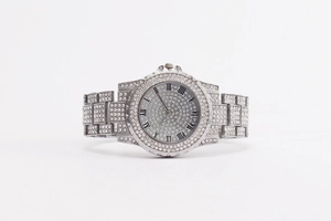 Close-up of sparkling silver rhinestone watch with roman numerals on white background