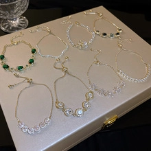 Flat lay of elegant gold and silver bracelets with green gemstones in a jewelry box