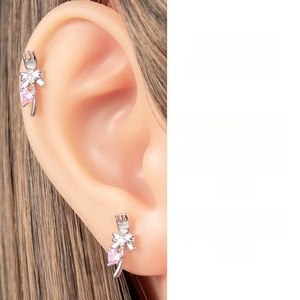 Detail of silver cartilage stud featuring pink heart zircon and bowknot tulip design
