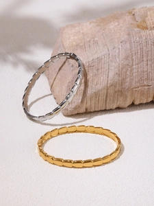 Detailed close-up of geometric link buckle bracelet in gold and silver stainless steel