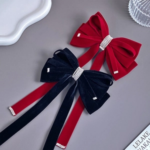 Velvet bow hair clip with rhinestone tassel details in red and black colors