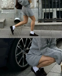 Détail d'un ensemble en tricot gris avec pull à revers et jupe assortie à taille haute