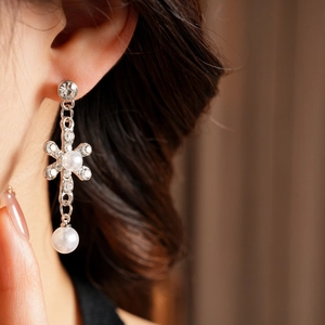 Detail of silver floral drop earring with sparkling crystals and white pearls on model